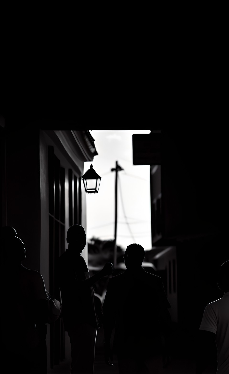 an excited bahamian man tells a story to a group of friends in a street in bahamas. b&w. preview